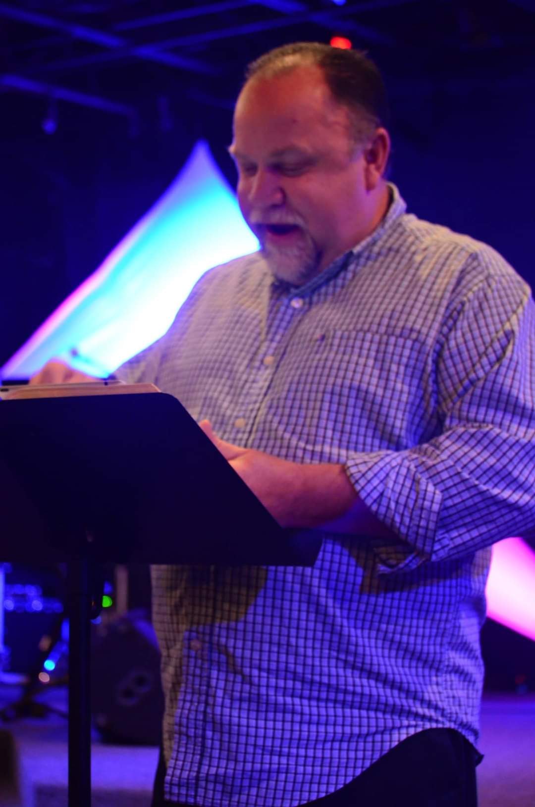 Bishop Dr. Jeffrey W. Larson preaching on a stage.